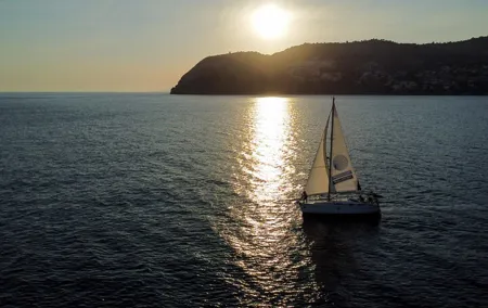 Sailing at sunset along the cliffs of Maro-Compartida